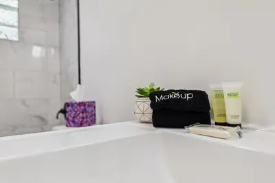 a bathroom counter with cosmetics and a bottle of moisturizers at Charming 3-Bedroom - Hot Tub & Game Room in Vermilion