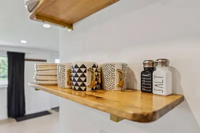 a wooden shelf with mugs on it in a kitchen at Charming 3-Bedroom - Hot Tub & Game Room in Vermilion