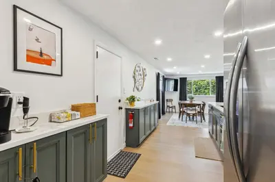 a kitchen with green cabinets and a refrigerator at Charming 3-Bedroom - Hot Tub & Game Room in Vermilion