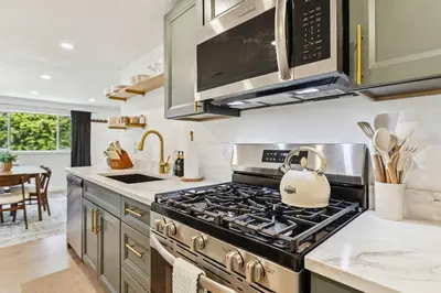 a kitchen with a stove with a tea kettle on it at Charming 3-Bedroom - Hot Tub & Game Room in Vermilion