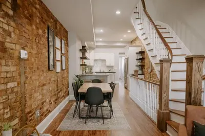 a dining room with a table and a brick wall at Stunning 4BR Townhome Rooftop City Views in Cincinnati
