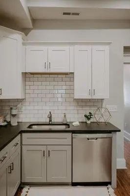 a kitchen with white cabinets and a sink at Stunning 4BR Townhome Rooftop City Views in Cincinnati