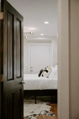 a bedroom with a bed with white sheets and a window at Stunning 4BR Townhome Rooftop City Views in Cincinnati