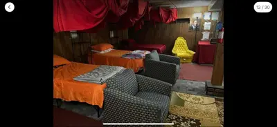 a room with two beds and a chair and a bed at Tarawa drive in Cincinnati