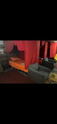 a bed and chairs in a room with a red curtain at Tarawa drive in Cincinnati