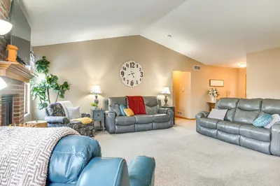 a living room with a couch and a clock on the wall at 17 Mi to Columbus Pickerington Home with Fire Pit! in Pickerington