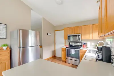 a kitchen with wooden cabinets and a stainless steel refrigerator at 17 Mi to Columbus Pickerington Home with Fire Pit! in Pickerington