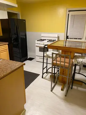 a kitchen with a table and a stove and a refrigerator at Cozy Studio Private room in Cincinnati