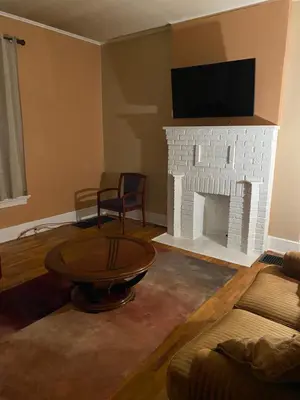 a living room with a fireplace and a tv on a wall at Cozy Studio private room deluxe in Cincinnati