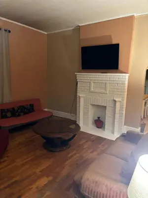 a living room with a fireplace and a tv at Cozy Studio private room deluxe in Cincinnati