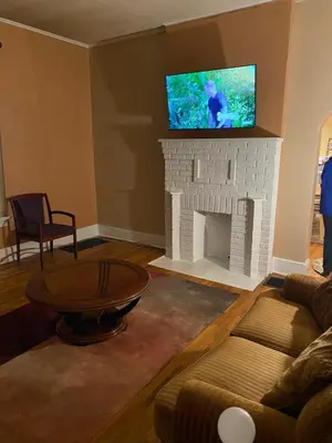 a living room with a fireplace with a tv on top at Cozy Studio private room deluxe in Cincinnati