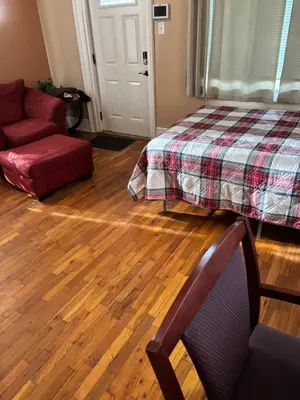 a living room with a bed and a couch and wooden floors at Cozy Studio private room deluxe in Cincinnati
