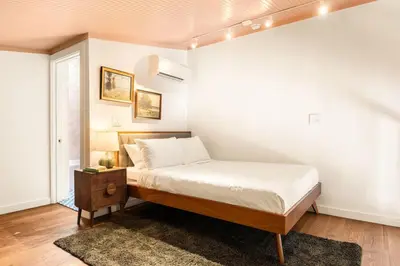 a bedroom with a bed and a white wall at Luxury Loft near Washington Park - Rooftop Deck in Cincinnati
