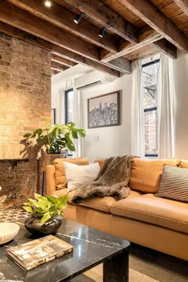 a living room with a couch and a brick wall at Luxury Loft near Washington Park - Rooftop Deck in Cincinnati