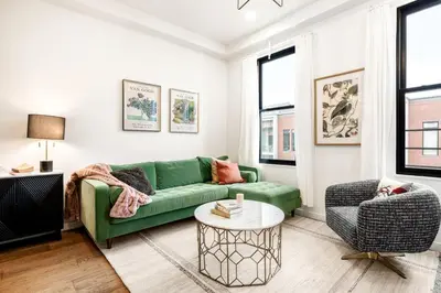 a living room with a green couch and a table at Washington Park - Rooftop Patio - Free Streetcar in Cincinnati