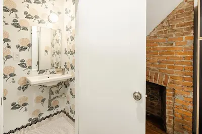a bathroom with a sink and a brick fireplace at Washington Park - Rooftop Patio - Free Streetcar in Cincinnati