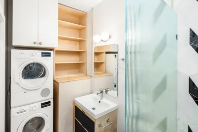 a small bathroom with a washing machine and a sink at Walk to ALL - Washington Park - FREE Streetcar in Cincinnati