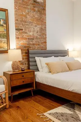 a bedroom with a bed and a brick wall at Walk to ALL - Washington Park - Gorgeous 2BR Condo in Cincinnati