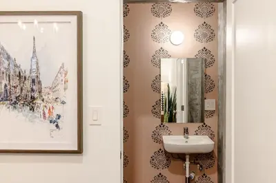 a bathroom with a sink and a mirror on a wall at Walk to ALL - Washington Park - Gorgeous 2BR Condo in Cincinnati