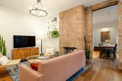 a living room with a brick fireplace and a couch at Walk to ALL - Washington Park - Gorgeous 2BR Condo in Cincinnati