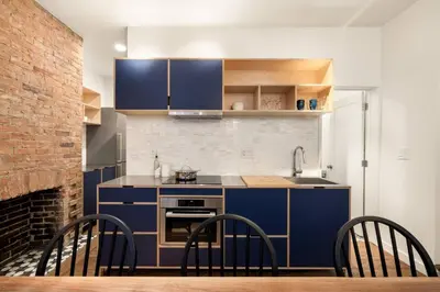 a kitchen with blue cabinets and a table and chairs at Walk to ALL - Washington Park - Gorgeous 2BR Condo in Cincinnati