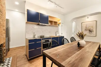 a kitchen and dining room with blue cabinets and a wooden table at Walk to ALL - Washington Park - Gorgeous 2BR Condo in Cincinnati