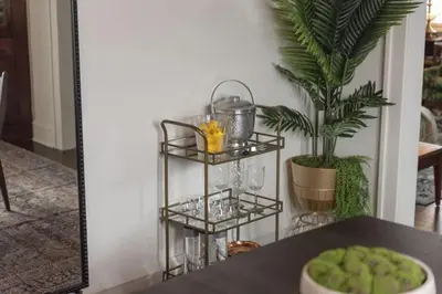 a black shelf with glasses and a plant on a table at Hot Tub - Game Room - Chic & Spacious - Sleeps 10 in Cleveland