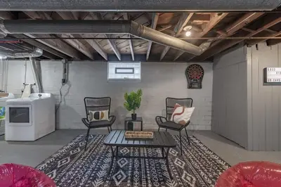 a living room with two chairs and a table at Hot Tub - Game Room - Chic & Spacious - Sleeps 10 in Cleveland