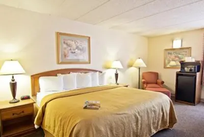 a hotel room with a bed and a chair at Quality Inn Chillicothe in Chillicothe