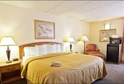 a hotel room with a bed and a chair at Quality Inn Chillicothe in Chillicothe