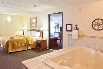 a hotel room with a bed and a bath tub at Quality Inn Chillicothe in Chillicothe