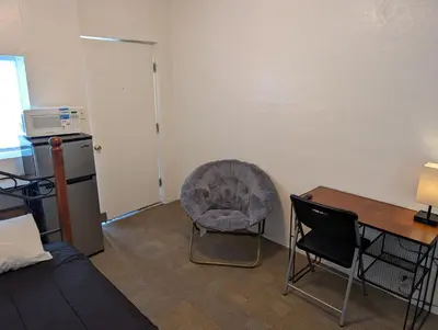 a room with a chair and a desk and a table at Terry Point Motel in Richfield