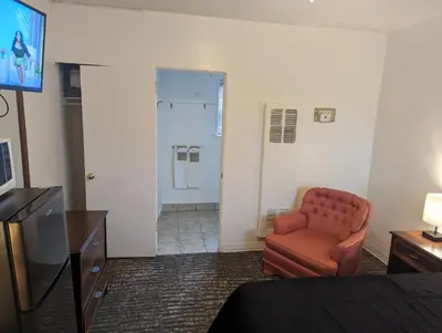a room with a chair and a television and a bathroom at Terry Point Motel in Richfield