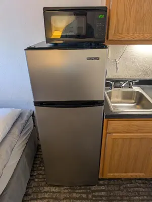 a microwave on top of a refrigerator in a kitchen at Terry Point Motel in Richfield