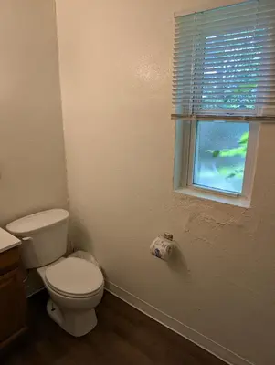a bathroom with a toilet and a window at Terry Point Motel in Richfield