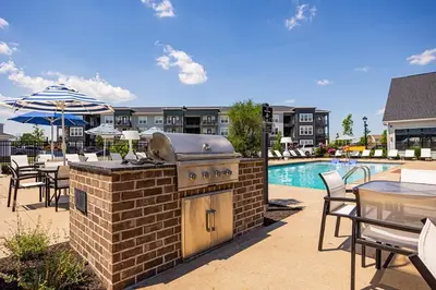 a outdoor grill with a table and chairs and a pool at The Dublin Designer 1st Floor Available Now in Dublin