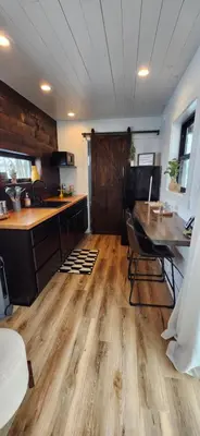 a kitchen with wooden floors and a table with chairs at Wildwood Retreat in Dalton