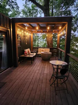 a wooden deck with a couch and a tub on it at Wildwood Retreat in Dalton