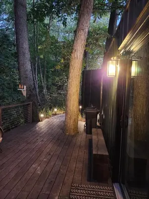 a wooden deck with a tree in the middle at Wildwood Retreat in Dalton