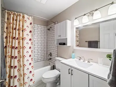 a bathroom with a sink and a toilet and a shower curtain at Vermilion Retreat with Game Room, Hot Tub and Across from Community Pool in Vermilion