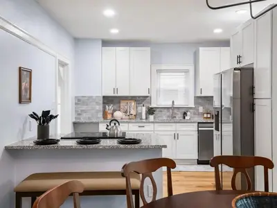 a kitchen with white cabinets and a table and chairs at 4 Bed 2 Bath Walk to Lakewood Restaurants and Shops in Lakewood