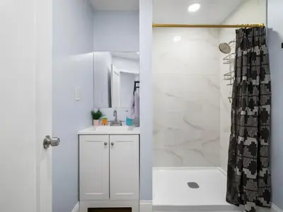 a white bathroom with a shower and a sink at 4 Bed 2 Bath Walk to Lakewood Restaurants and Shops in Lakewood