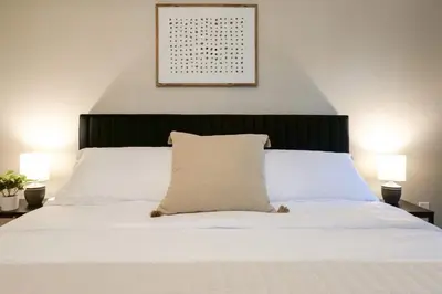 a bedroom with a white bed with two lamps at Modernized Historical Home in Downtown Medina with Hot Tub in Medina