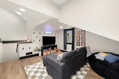 a living room with a couch and a flat screen tv at Modernized Historical Home in Downtown Medina with Hot Tub in Medina