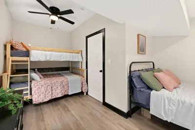 a bedroom with two bunk beds and a ceiling fan at Modernized Historical Home in Downtown Medina with Hot Tub in Medina