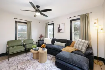 a living room with a couch and a ceiling fan at Modernized Historical Home in Downtown Medina with Hot Tub in Medina