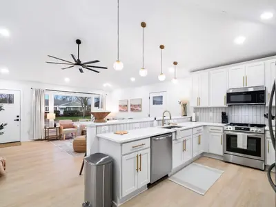 a kitchen with white cabinets and stainless steel appliances at Luxurious Retreat with Sauna and Modern Design in Warrensville Heights