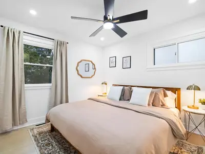 a bedroom with a large bed with a ceiling fan at Luxurious Retreat with Sauna and Modern Design in Warrensville Heights