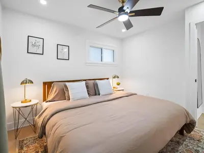 a bedroom with a large bed with a ceiling fan at Luxurious Retreat with Sauna and Modern Design in Warrensville Heights