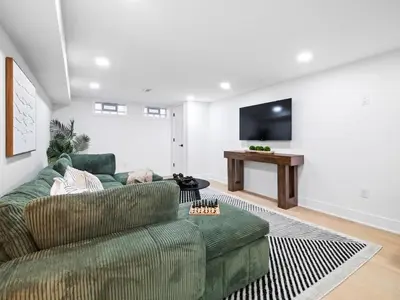 a living room with a green couch and a flat screen tv at Luxurious Retreat with Sauna and Modern Design in Warrensville Heights